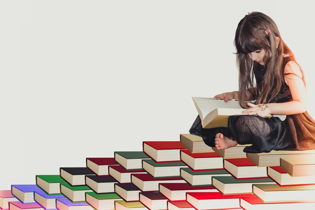 坐在書堆上讀書的小女孩